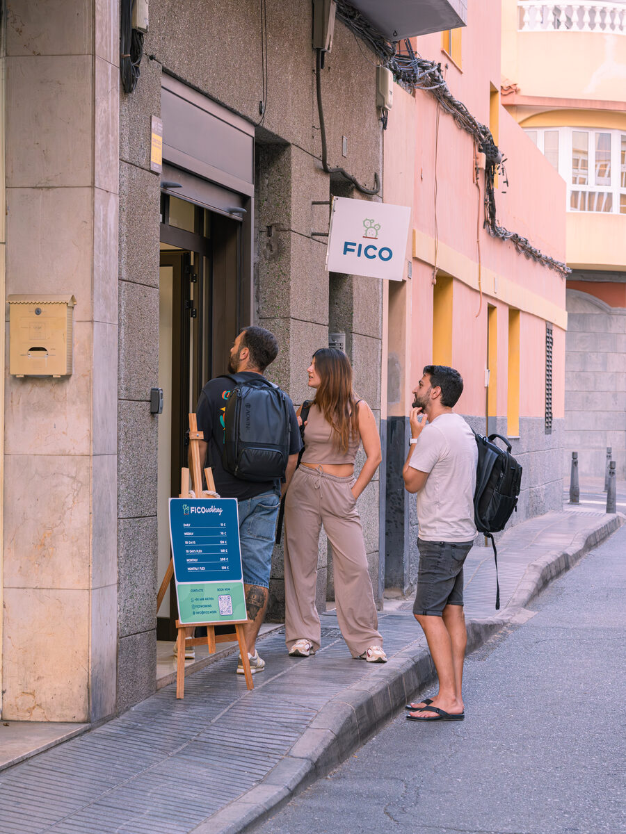 Three people arriving at FICO's door on a La Isleta street